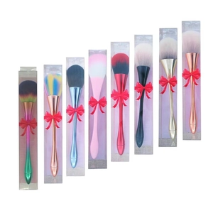 Detailed view of colorful makeup brushes individually boxed with red ribbon bows