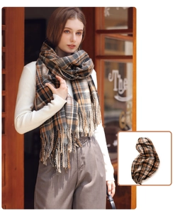 Detailed view of the classic brown plaid winter scarf with fringe edges and soft texture