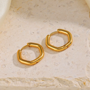 Orecchini esagonali con placcatura in oro 18K su sfondo di pietra naturale e seta morbida