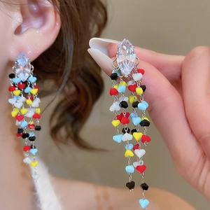 Close-up of bohemian tassel earrings with marquise crystal and colorful heart beads