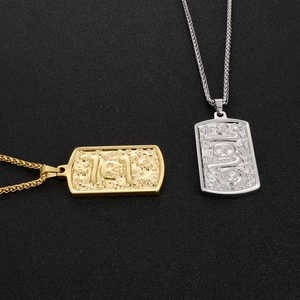 Detail of square titanium steel pendants with 3D skull relief in gold and silver