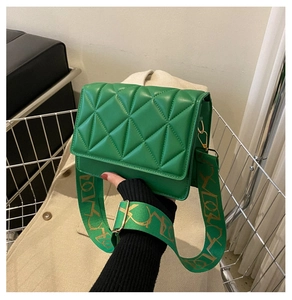 Detail of green quilted leather square bag with artistic golden texture wide strap