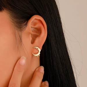 Close-up of vintage gold molten drip earrings on model with irregular C-shape design