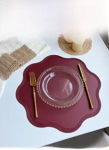 Macro view of dark red petal-edged faux leather placemat with refined grain texture