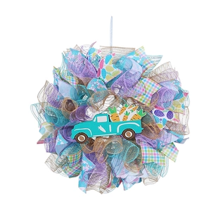 Detailed view of Easter wreath with mesh ribbon, teal truck pendant, and carrot accents