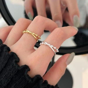 Minimalist double-layered silver ring with beads and cross design on a model's finger