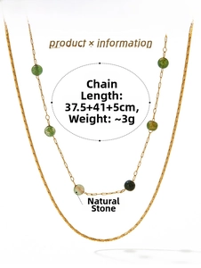 Detail of double-layer gold necklace with green natural stones and flat snake chain
