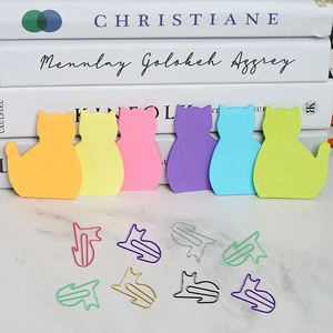 Close-up of cute cat-shaped sticky notes and multi-colored metal paper clips set
