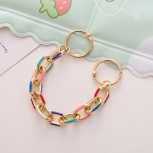 Close-up of colorful enamel metal shoe chains for DIY charms on a pastel background