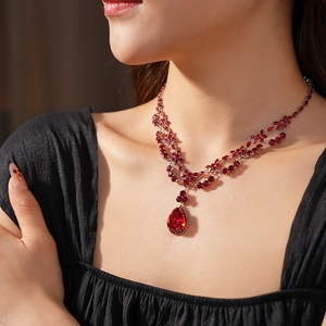 Detail of luxury red crystal pear pendant necklace with tiered zircon accents
