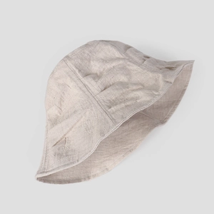 Close-up of lightweight linen sun hat showing natural fabric texture and pleated stitching