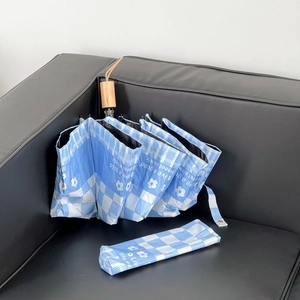 Blue and white checkered umbrella with floral pattern and rustic wooden handle