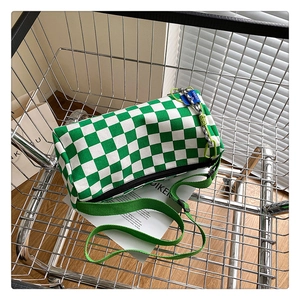 Top view of green and white checkerboard Boston bag in a metal shopping cart