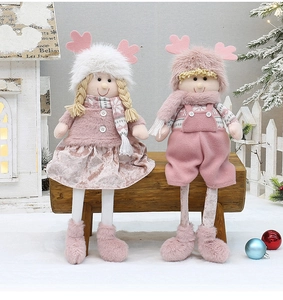 Close-up of pink plush Christmas dolls with knit details in a cozy winter snow scene
