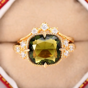 Makro-Detail des Kronenrings mit olivgrünem Kissen-Schliff-Stein in Goldplattierung