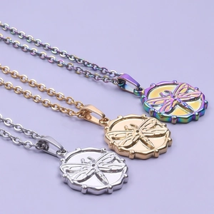 Detail view of dragonfly relief pendants in silver, gold, and colorful steel finishes