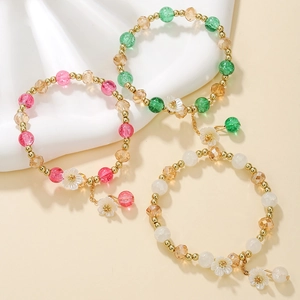 Lot de trois bracelets en perles de cristal avec breloques fleurs en rouge, vert et blanc