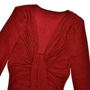 Gros plan d'une robe rouge scintillante à col en V avec nœud et détails froncés