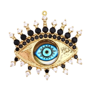 Detailed view of gold plated evil eye charm with blue center and sparkling zircon stones