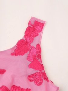 Detail of pink floral embroidery on sheer mesh fabric of a sexy bodycon dress