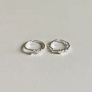 Detail of silver S925 rings featuring a cute bow and heart design with adjustable bands
