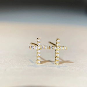 Vue macro de boucles d'oreilles croix en argent S925 doré avec pierre en moissanite