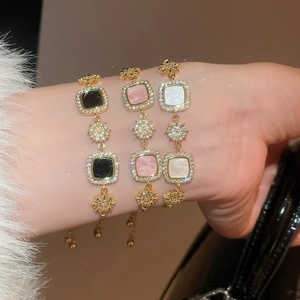 Détail de bracelets élégants plaqués or 18 carats avec pierres carrées et zircons fins