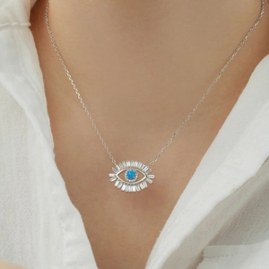 Close-up of S925 silver Evil Eye necklace with blue stone and sparkling zircons on model