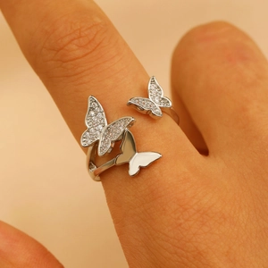 Close-up of sparkling cubic zirconia paved butterfly ring on finger in silver finish