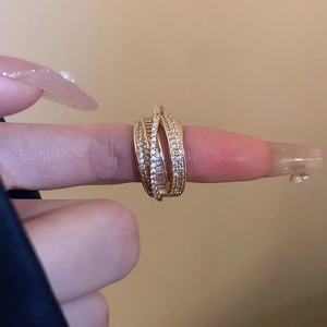 Close-up of golden multi-layer crisscross ring with micro-pave white zircon crystals