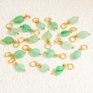 Detailed macro view of green translucent stone pendants with gold metal rings for DIY jewelry