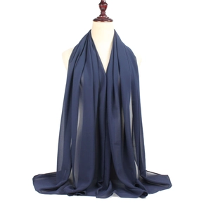 Detailed draping of a navy blue chiffon hijab scarf on a mannequin torso display