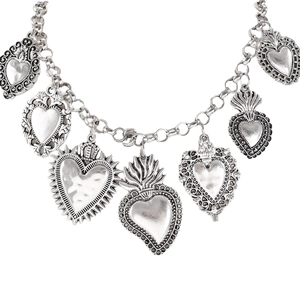 Detail of silver vintage necklace featuring multiple Sacred Heart pendants with ornate carvings
