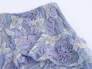 Détail de la jupe en tulle violet avec broderie florale crème et bords volantés
