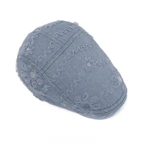 Top view of blue denim newsboy cap with floral lace embroidery and silver sequins