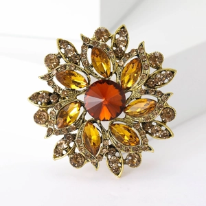 Detail of vintage sunflower brooch with orange crystals and antique gold finish