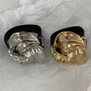 Macro-opname van zilveren en gouden metalen bloemen op brede zwarte lederen armbanden