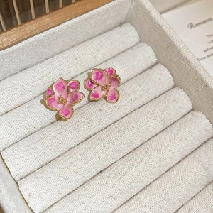 Vintage sweet pink enamel flower stud earrings with gold plating on a beige velvet tray