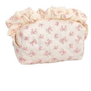 Floral bow makeup bag with diamond quilting and ruffled trim in minimalist white
