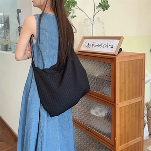 Détail du tissu gaufré à bulles et de la boucle de bandoulière sur ce sac noir chic