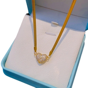 Luxury gold heart pendant necklace with shimmering white zircons in a light blue jewelry box
