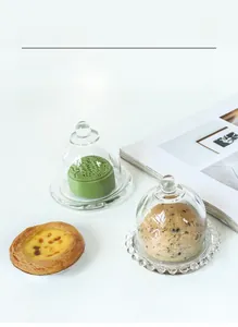 Detail view of clear crystal glass cake domes showing two styles with elegant pastry displays