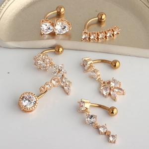 Golden belly button rings set with sparkling heart and flower crystal zircon charms