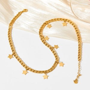 Minimalist gold star pendant necklace with Cuban chain on elegant silk background