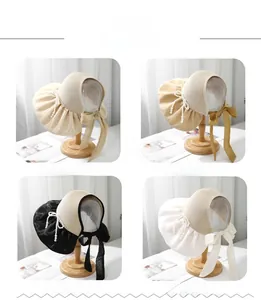 Detailed view of four straw sun visors with pearl fringe and large fabric bows