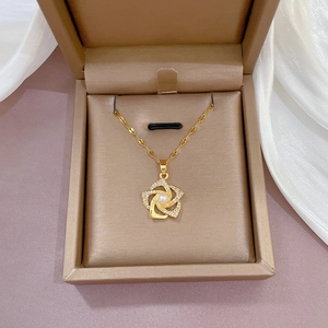 Gold rotating flower necklace with micro-paved zircons and a pearl pendant on silk