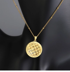 Close-up of golden hollow grid planet pendant on a black jewelry mannequin neck