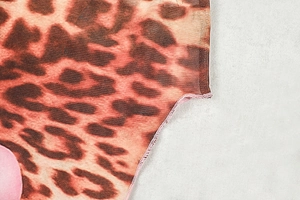Dettaglio del tessuto mesh leopardato con cuciture rifinite e trama traspirante