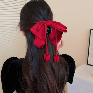 Vue arrière d'une grande pince à cheveux noeud en satin rouge pour coiffures élégantes