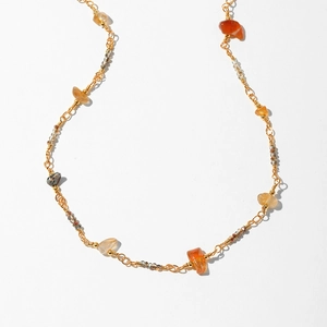 Detail of bohemian gold chain necklace with colorful gravel stones and small beads